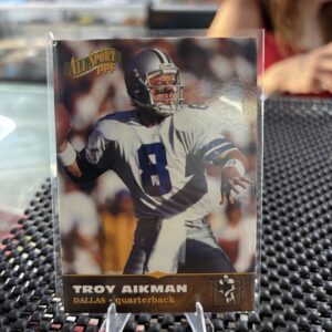 Dallas Cowboys Troy Aikman 1996 All Sport PPF football trading card, action shot in protective sleeve, high quality vintage NFL quarterback collectible in a clear display case for serious sports fans.