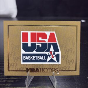 1992 USA Basketball Dream Team logo card, gold foil edition, vintage hoops collectible in protective sleeve, high quality rare treasure for serious basketball fans and card investors in North Las Vegas today.