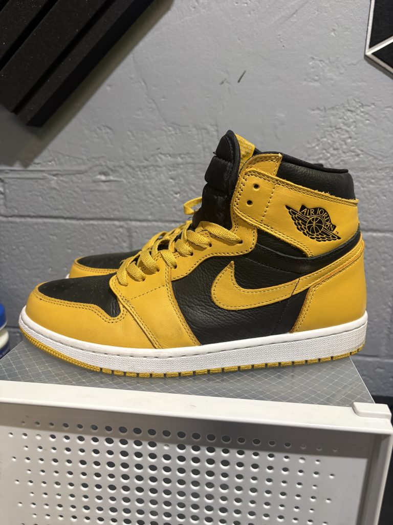 Air Jordan 1 Retro High OG in a black and yellow "Pollen" colorway, a highly sought-after sneaker for collectors looking to add high-value, stylish assets to their portfolio today.