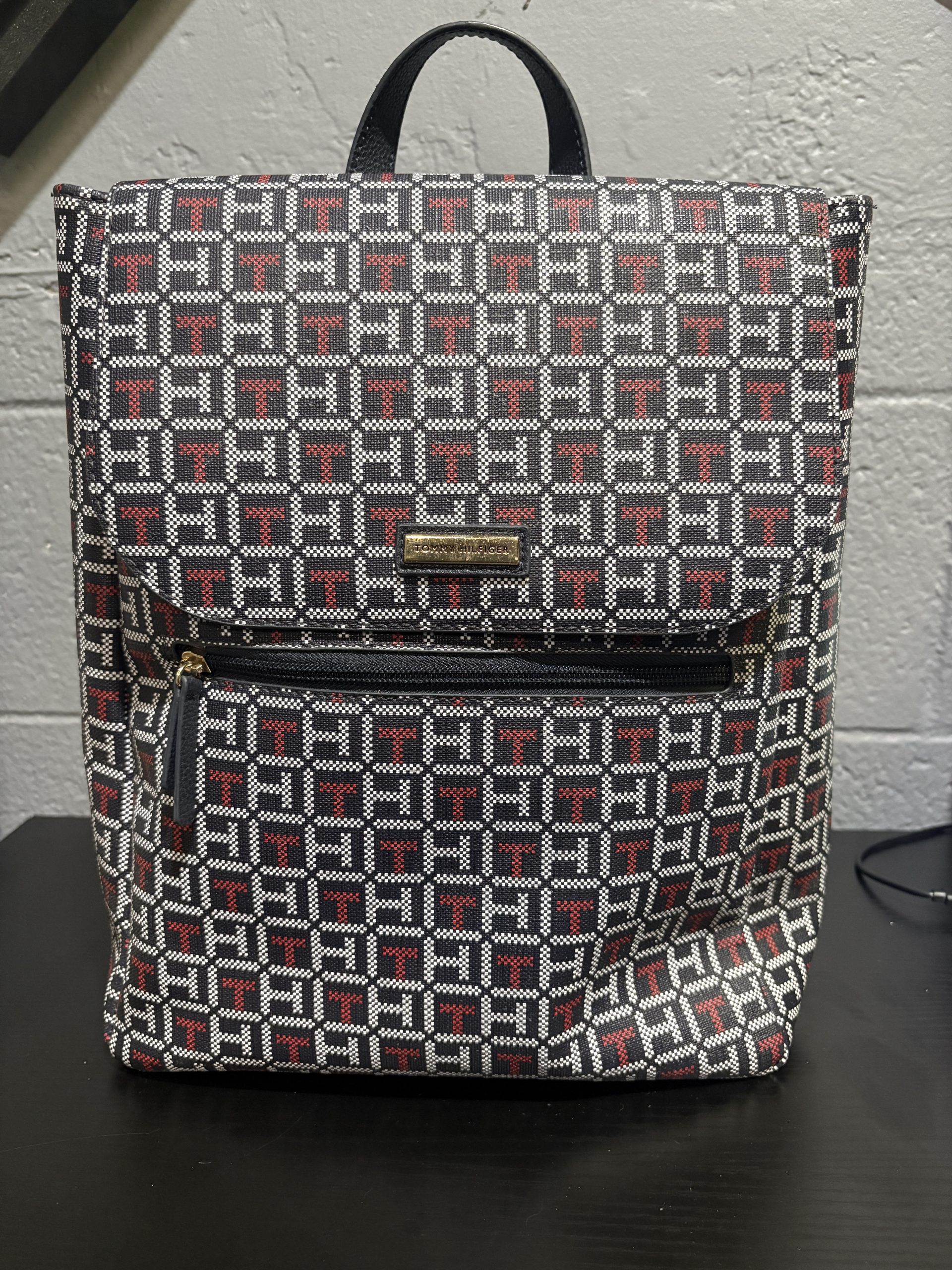 Stylish Tommy Hilfiger monogram backpack featuring the iconic brand pattern, a must-have designer accessory for those building a high-value, fashionable collection.