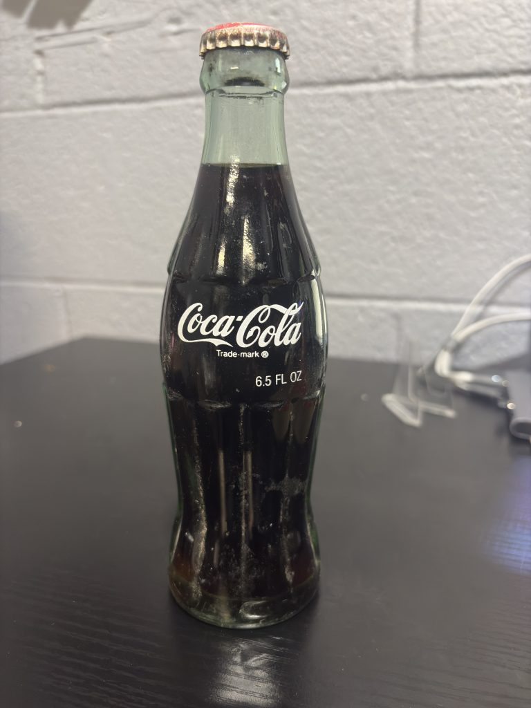 Rare international 6.5 fl oz Coca-Cola glass bottle from Pakistan, featuring unique Urdu script branding, a highly sought-after piece for global soda memorabilia collectors looking to add high-value, authentic assets to their collection today.