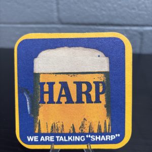 Unique vintage Harp Lager "We Are Talking Sharp" beer coaster with a humorous, surreal twist on the reverse side, a high-vibration collectible for enthusiasts of eccentric breweriana and brand history.