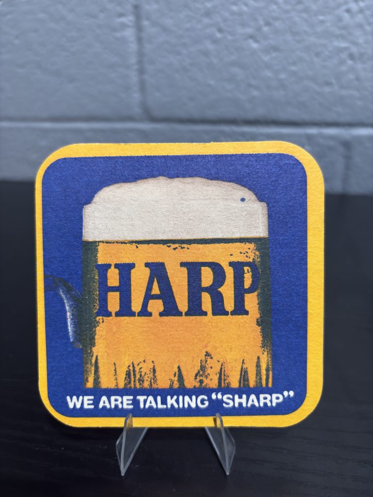 Unique vintage Harp Lager "We Are Talking Sharp" beer coaster with a humorous, surreal twist on the reverse side, a high-vibration collectible for enthusiasts of eccentric breweriana and brand history.