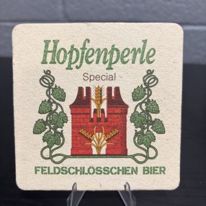 Vintage Feldschlösschen Bier "Hopfenperle" coaster, featuring elegant branding and a promotional image of a waiter, a high-vibration collectible perfect for enthusiasts of international breweriana looking to manifest prosperity and add authentic brand history to their portfolio.