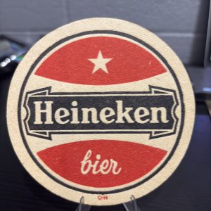 Rare vintage circular Heineken "bier" coaster with red branding and star motif, a high-vibration collectible perfect for enthusiasts of international brewing history looking to manifest prosperity today.