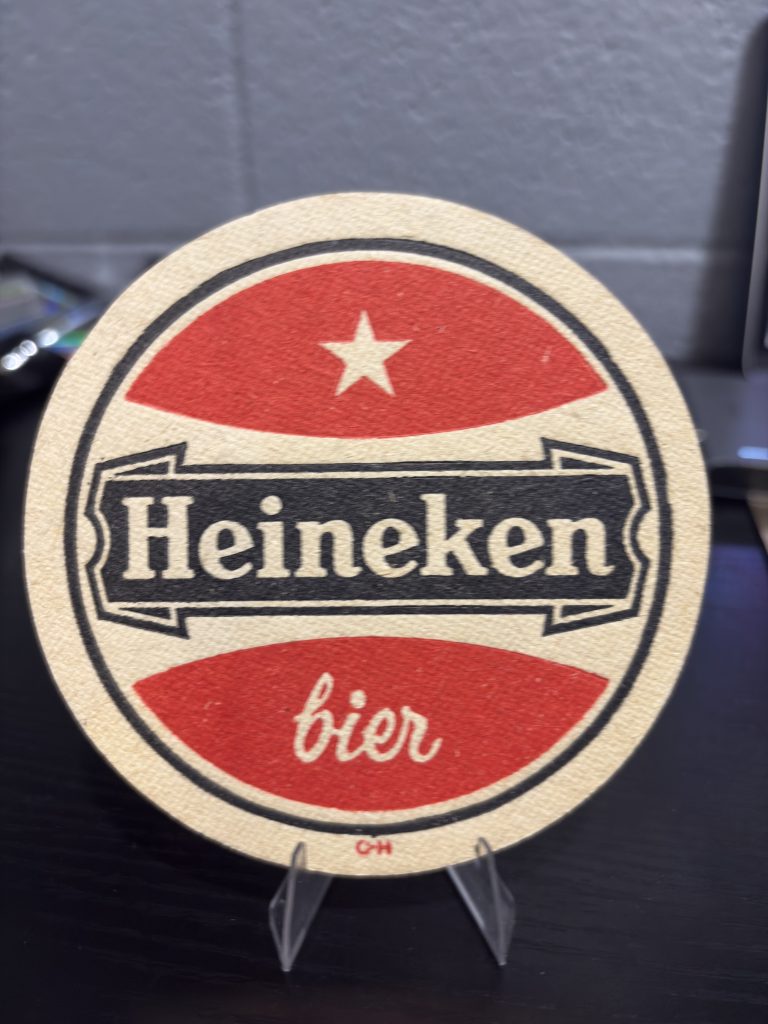 Rare vintage circular Heineken "bier" coaster with red branding and star motif, a high-vibration collectible perfect for enthusiasts of international brewing history looking to manifest prosperity today.