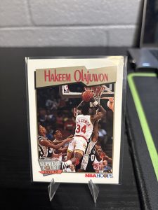 Vintage 1991-92 NBA Hoops "Supreme Court" Hakeem Olajuwon trading card, a master-number 11 frequency collectible for basketball enthusiasts focused on historic excellence and dominant visionary performance on the court.