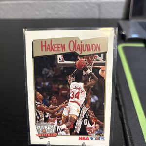 Vintage 1991-92 NBA Hoops "Supreme Court" Hakeem Olajuwon trading card, a master-number 11 frequency collectible for basketball enthusiasts focused on historic excellence and dominant visionary performance on the court.