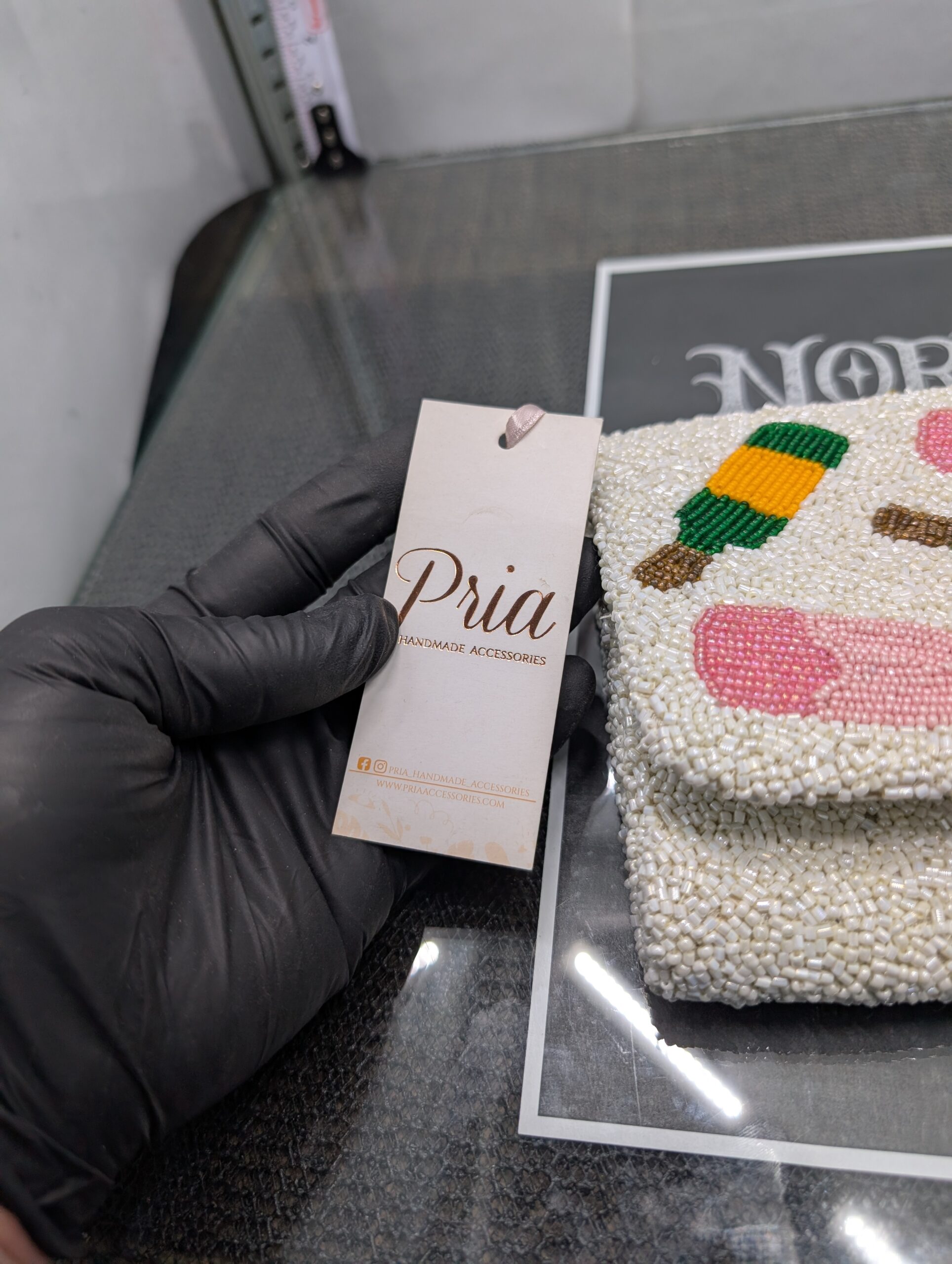 White beaded clutch purse featuring the words Pour More with colorful cocktail designs and a gold chain strap.
