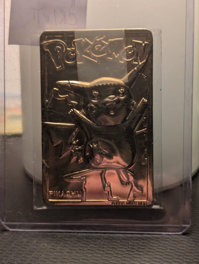 Vintage 1999 Burger King 23K gold-plated Pikachu Pokémon promotional trading card displayed on a black stand.