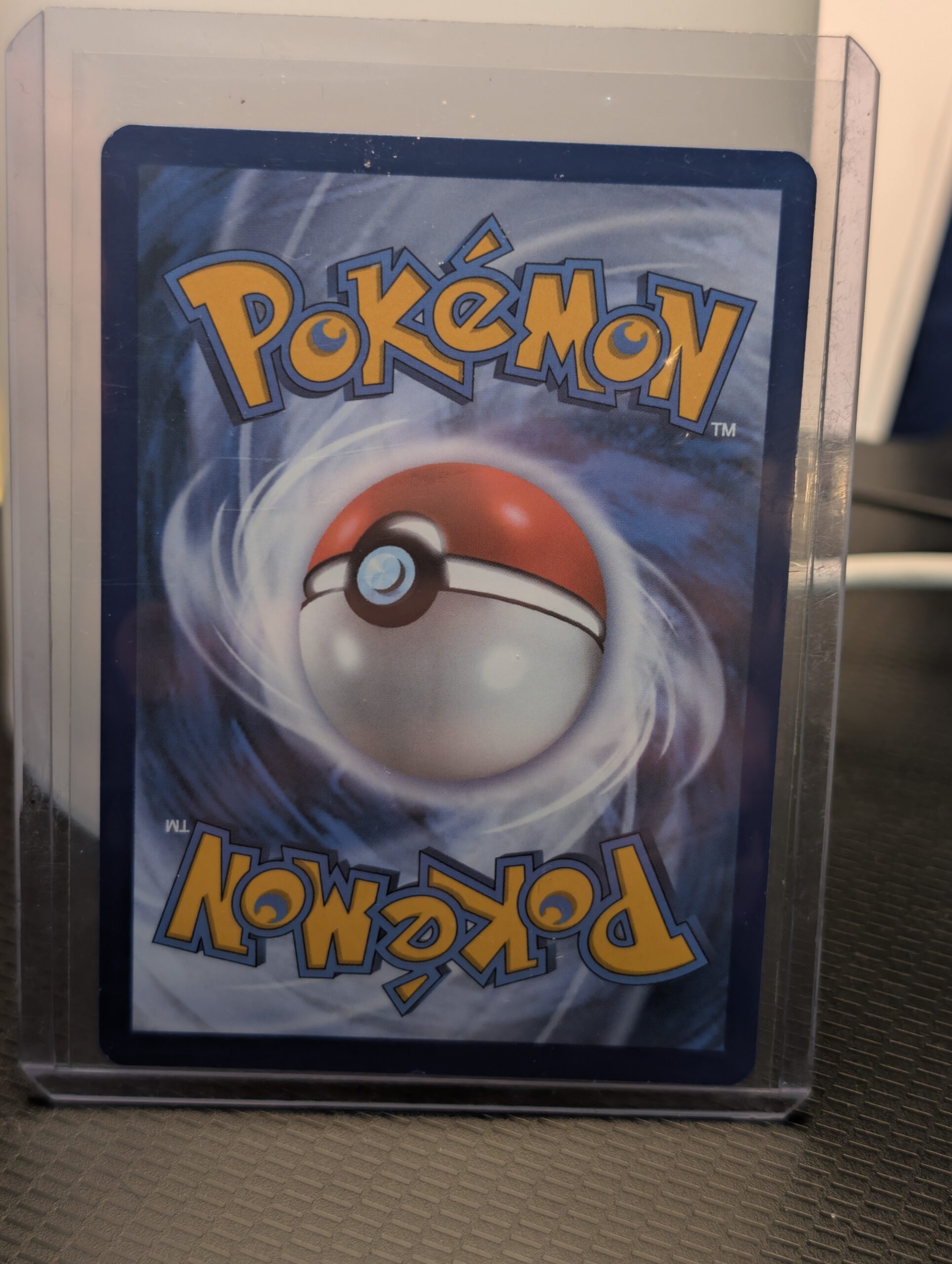 Back-side, Back of card, Holographic Alakazam Pokémon trading card, number 056/132 from the Mega Evolution expansion set, displayed in a clear protective plastic sleeve.
