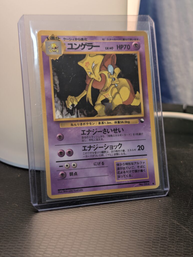 Vintage 1998 Japanese Kadabra Pokémon trading card, number 064 from the Vending Series 3 set, featuring Shin-ichi Yoshida artwork, displayed in a clear protective plastic sleeve.