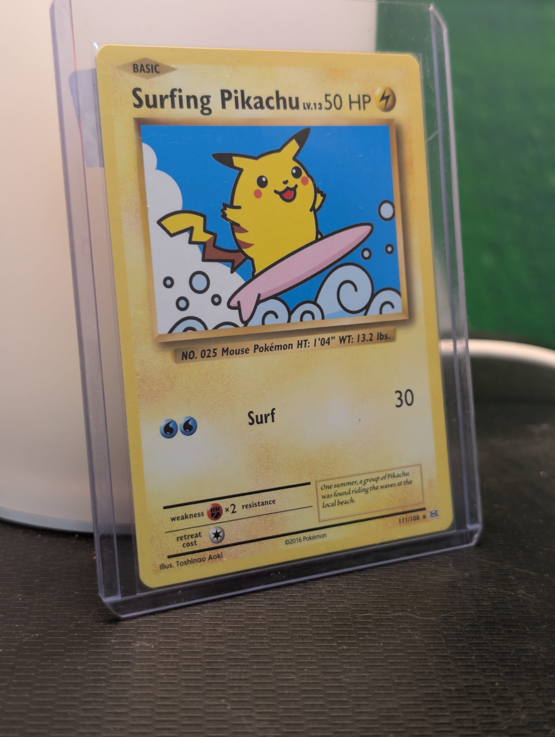 Surfing Pikachu Pokémon trading card, number 111/108 from the 2016 XY Evolutions expansion set, displayed in a clear protective plastic sleeve.
