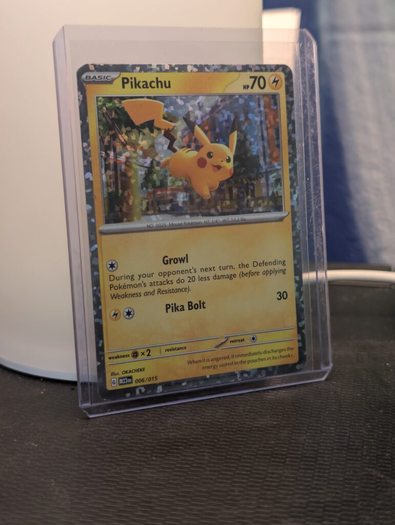 Holographic Pikachu Pokémon trading card, number 006/015 from the 2023 McDonald's Match Battle promo set, featuring a unique confetti holofoil pattern, displayed in a clear protective plastic sleeve.