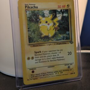 Vintage 1999 Jungle Set Pikachu Pokémon trading card, number 60/64, Unlimited print run, displayed in a clear protective plastic sleeve.