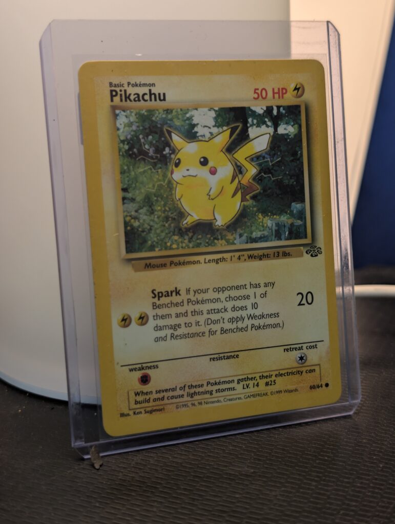Vintage 1999 Jungle Set Pikachu Pokémon trading card, number 60/64, Unlimited print run, displayed in a clear protective plastic sleeve.