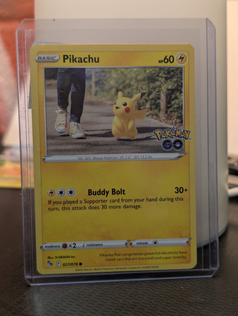 2022 Pokémon GO Pikachu trading card, number 027/078, featuring Pikachu walking on a sidewalk, displayed in a clear protective plastic sleeve.