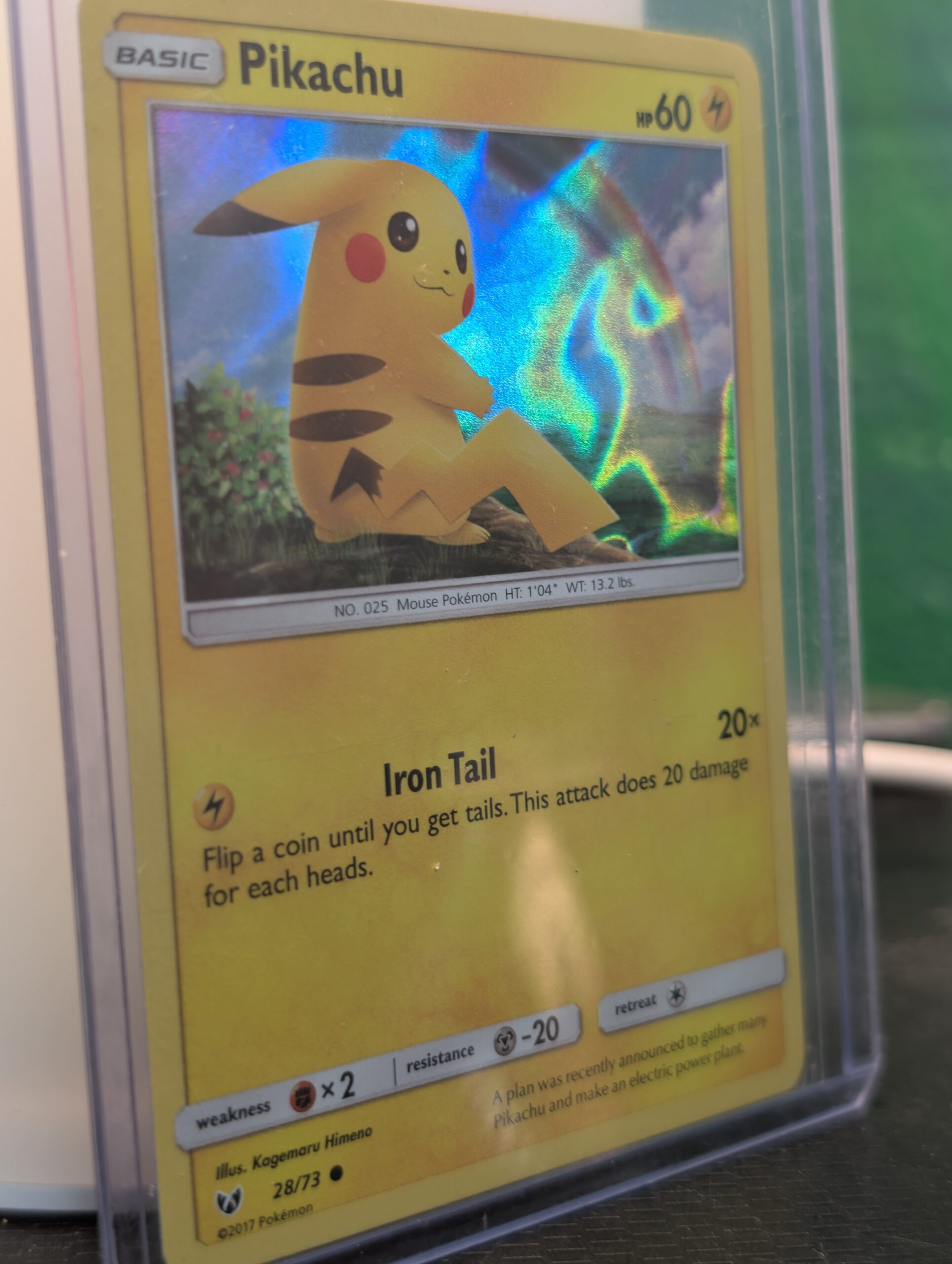 Holographic Pikachu Pokémon trading card, number 28/73 from the 2017 Shining Legends expansion, featuring the exclusive Cosmos holofoil pattern, displayed in a clear protective plastic sleeve.