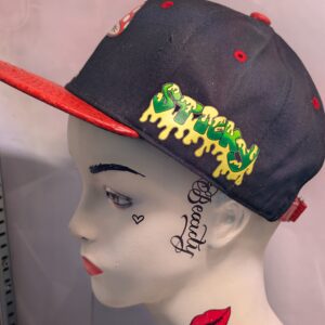 Black structured streetwear snapback hat featuring embroidered cartoon mushroom graphic alongside bright green dripping slime logo and textured red crocodile faux leather flat bill edge for style.
