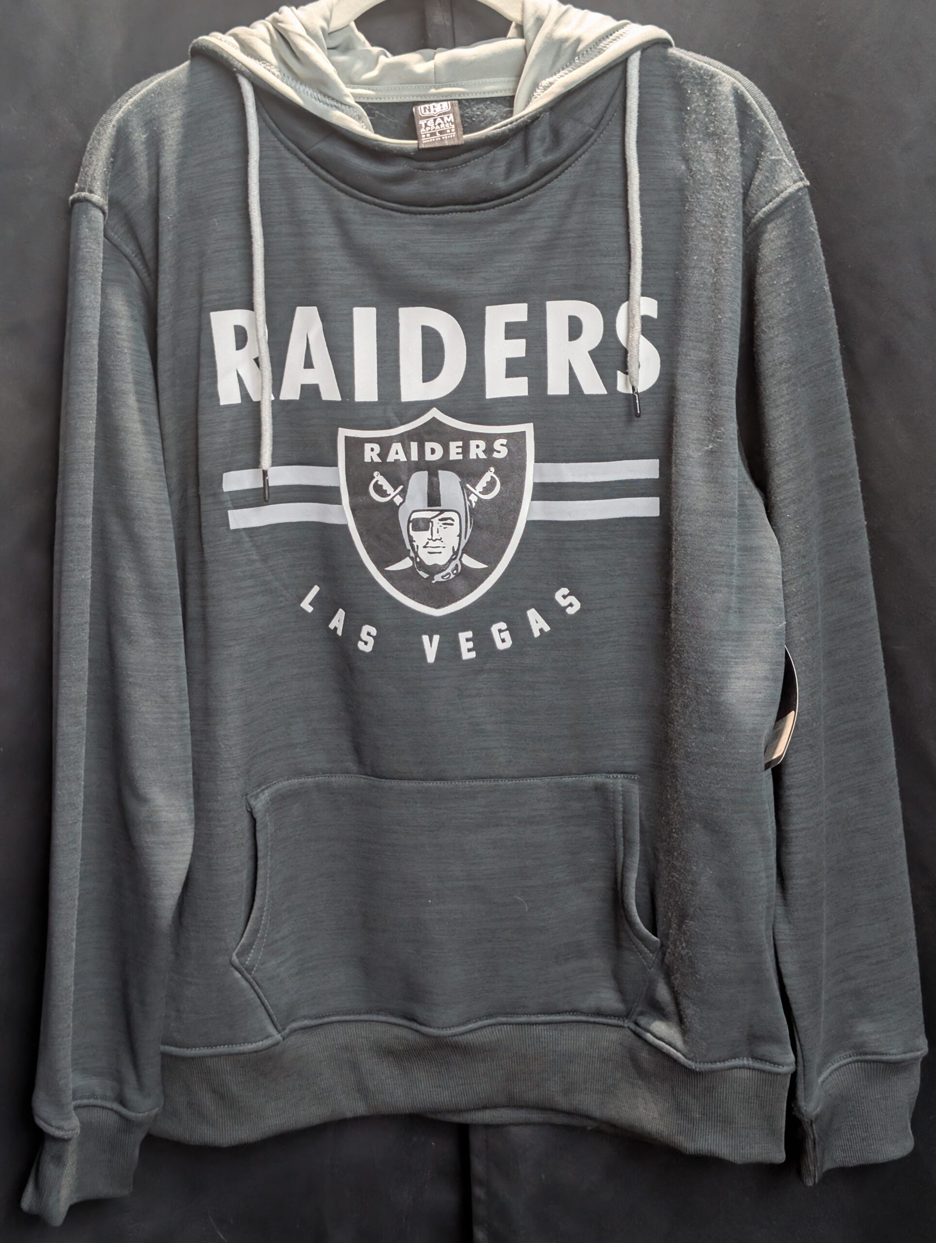 Brand new with tags official NFL Team Apparel size large Las Vegas Raiders heathered black pullover hoodie featuring classic team shield logo and convenient front kangaroo pocket today.