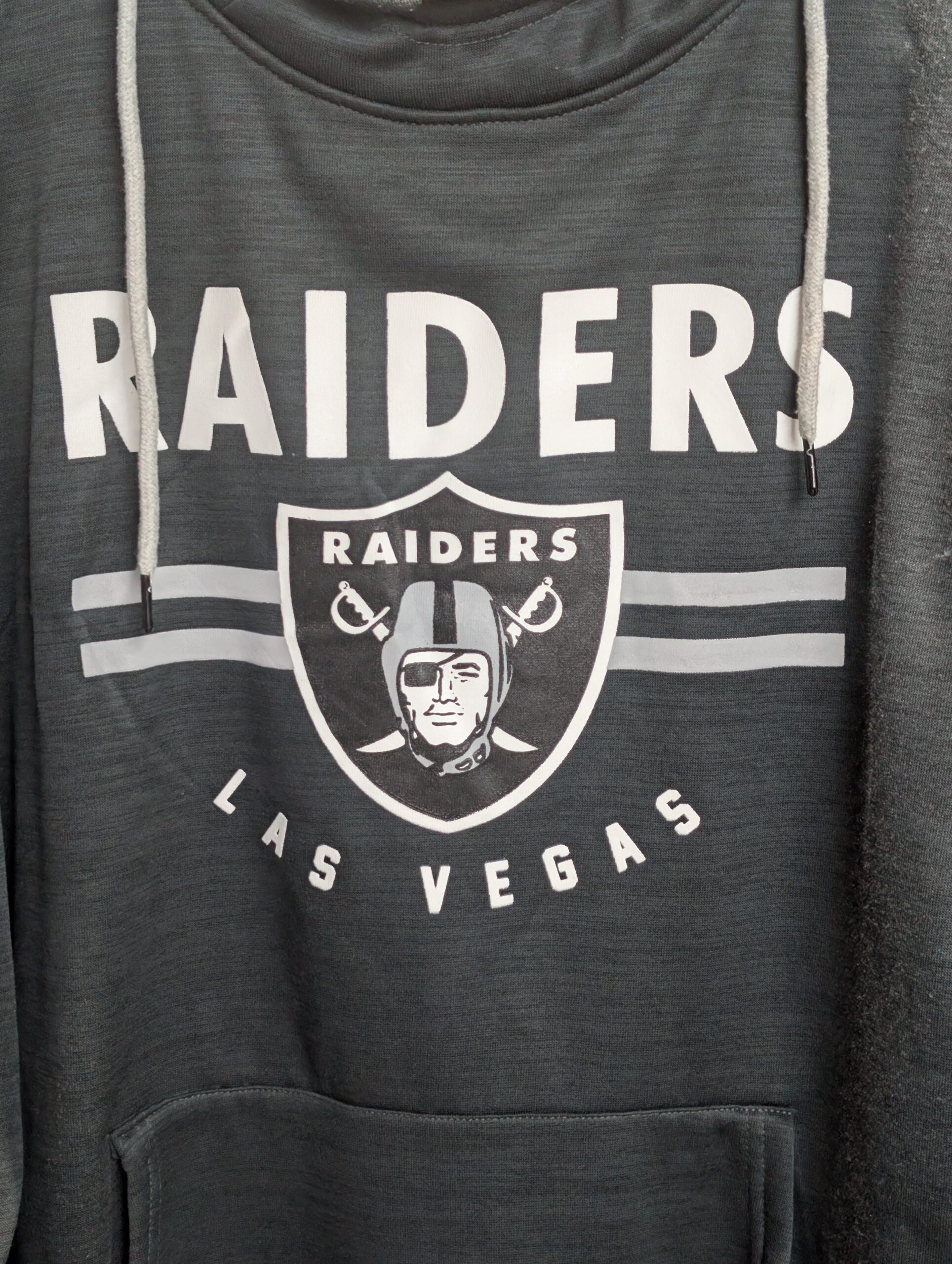 Brand new with tags official NFL Team Apparel size large Las Vegas Raiders heathered black pullover hoodie featuring classic team shield logo and convenient front kangaroo pocket today.