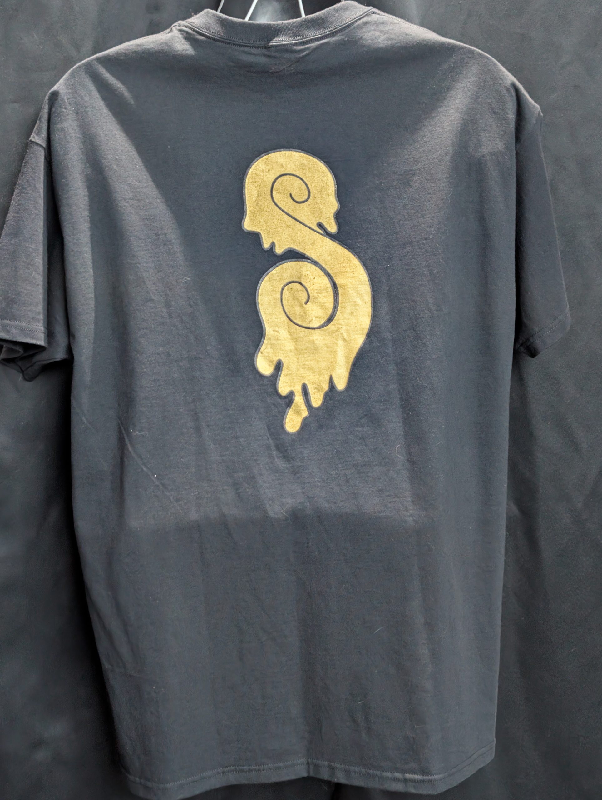 Black shirt featuring gold Sticky Canna drip logo.