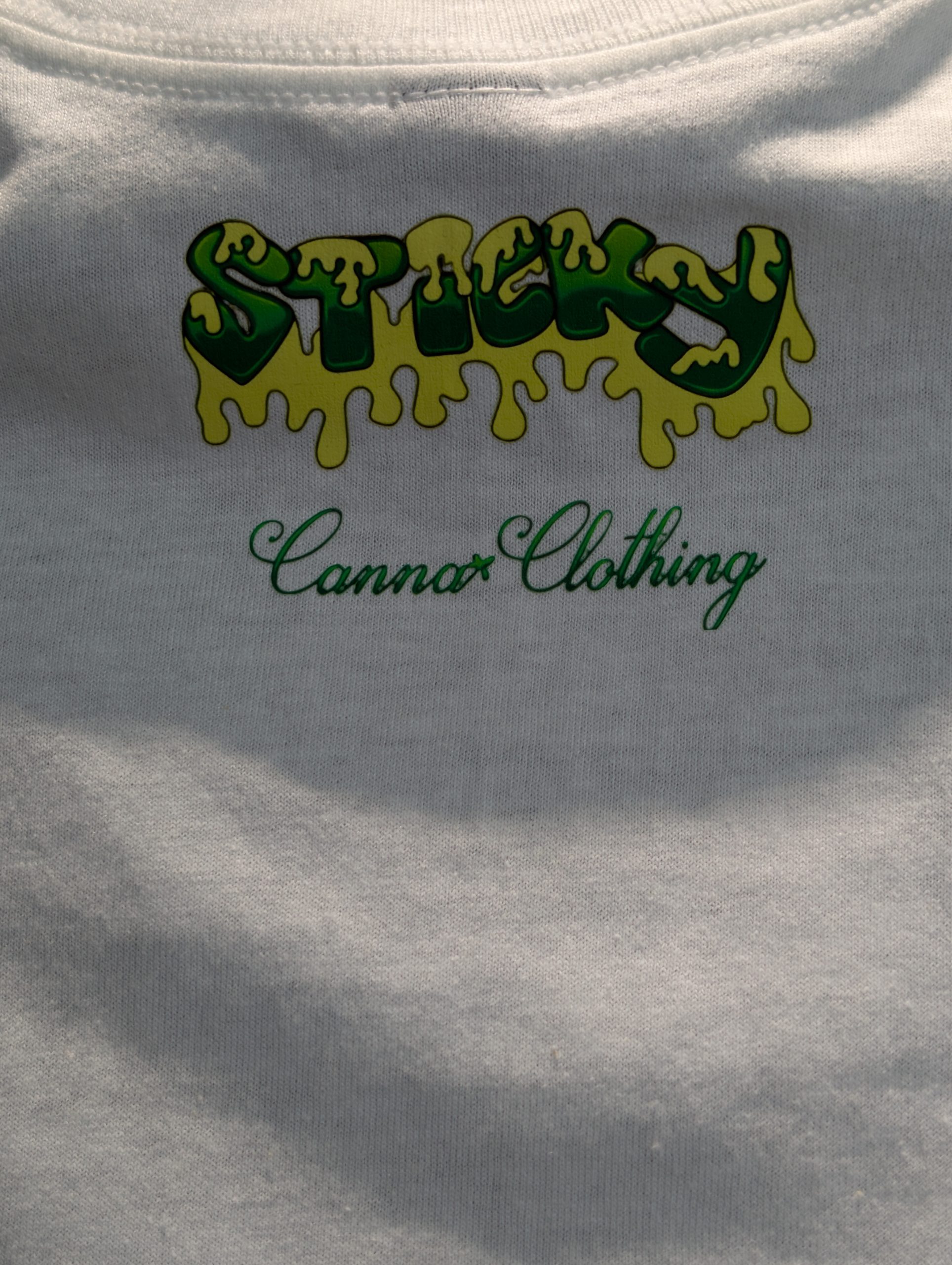 White shirt featuring blue wave Sticky Canna logo.