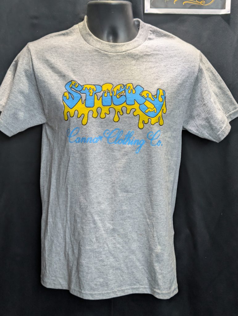 Grey shirt featuring blue yellow Sticky Canna logo.