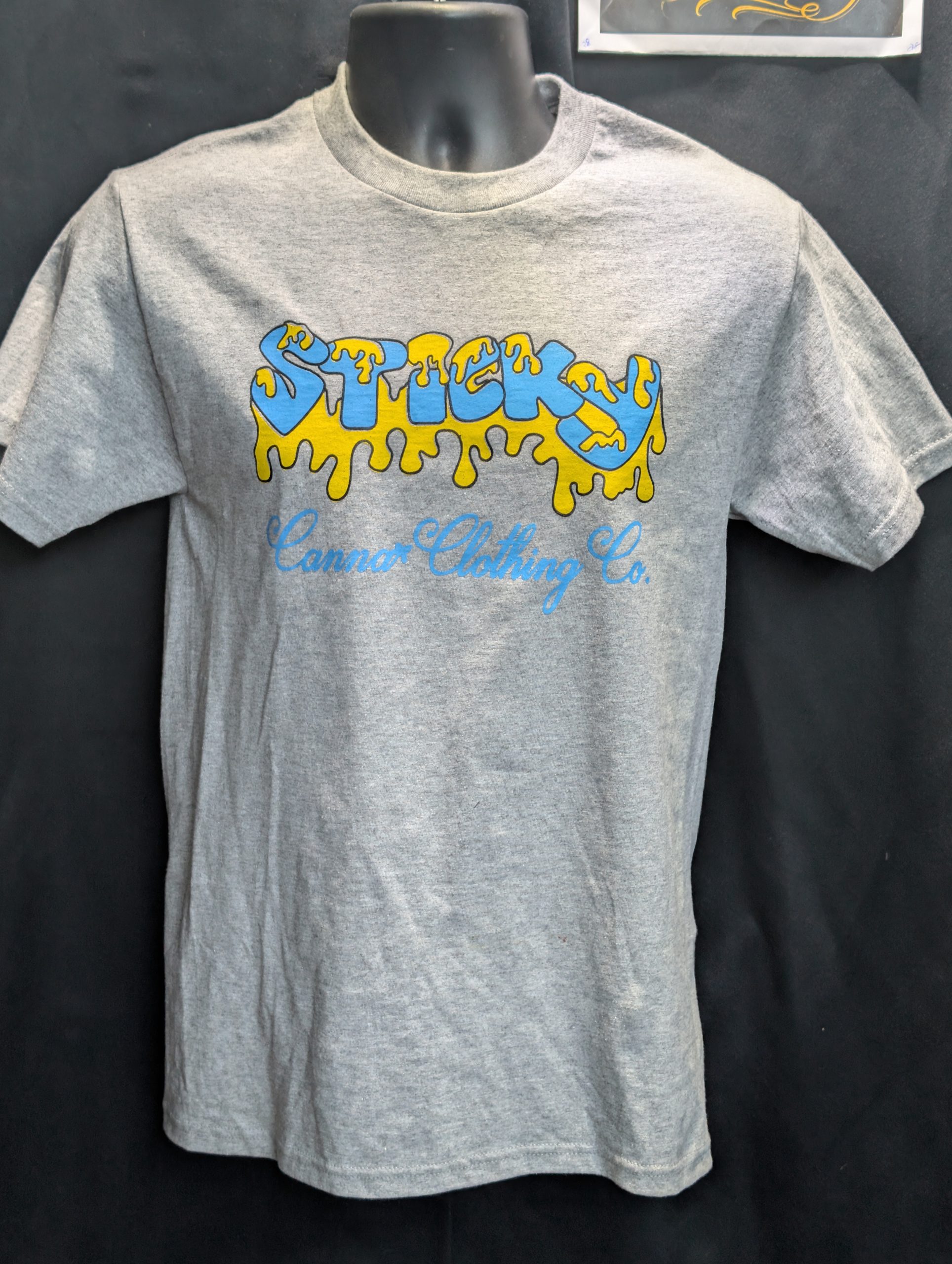 Grey shirt featuring blue yellow Sticky Canna logo.