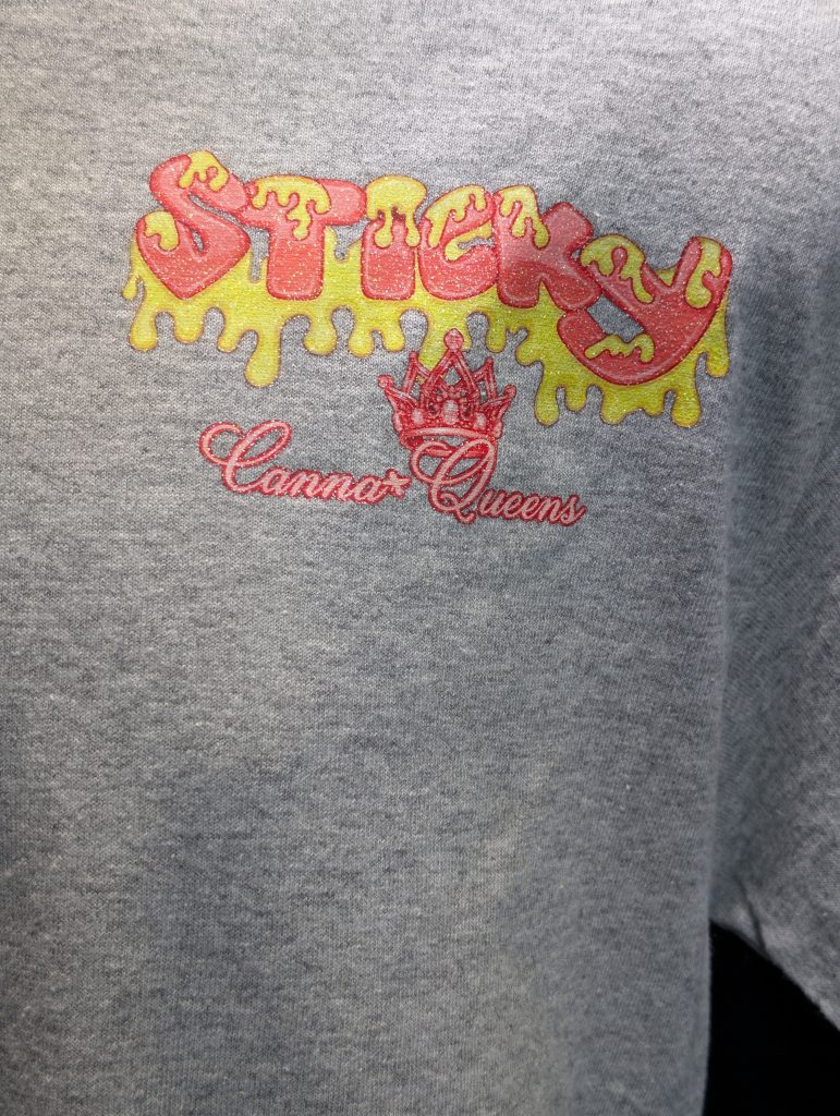 Grey shirt featuring pink yellow Sticky Queens logo.