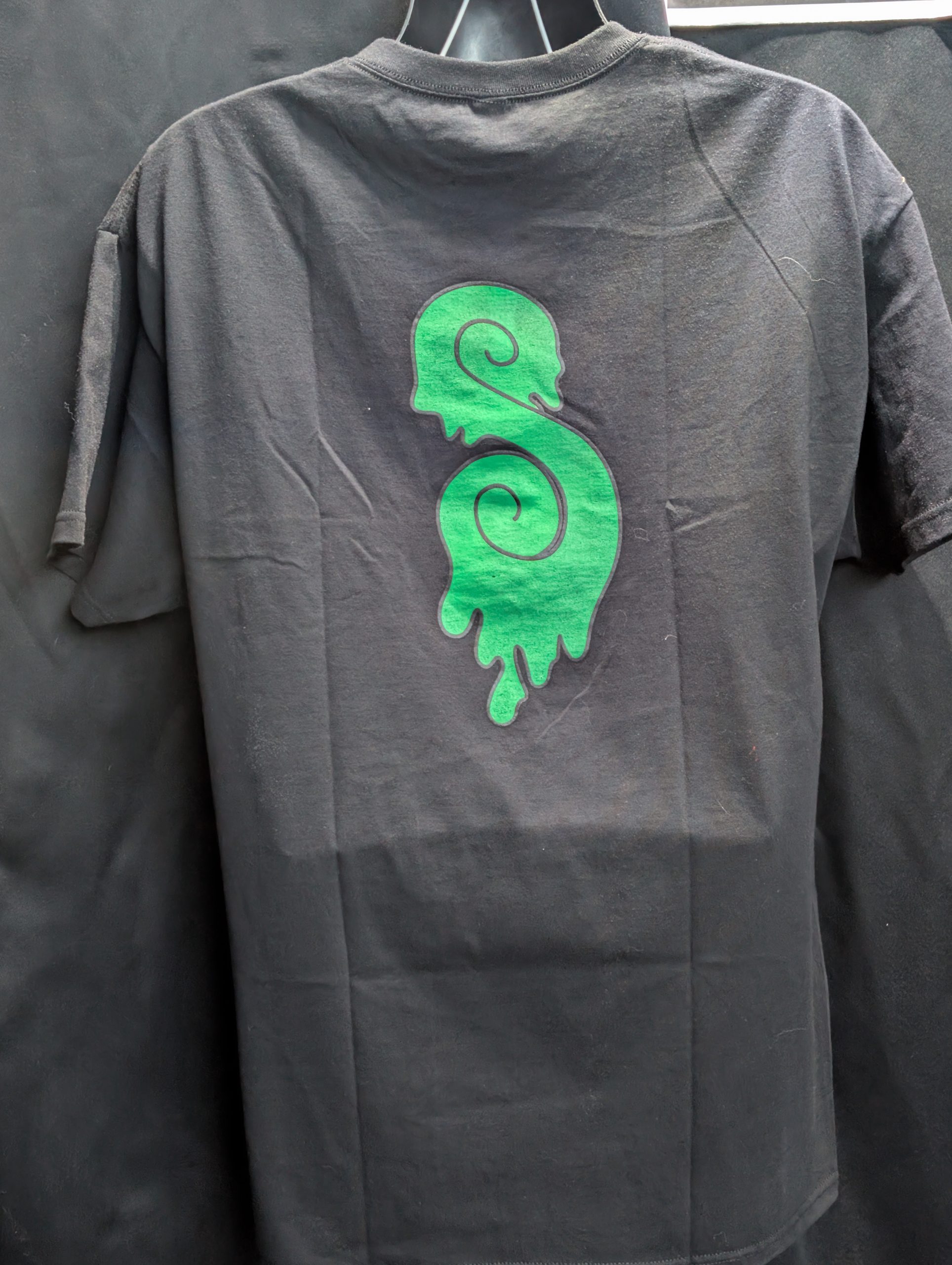 Black shirt featuring green Sticky Canna drip logo.