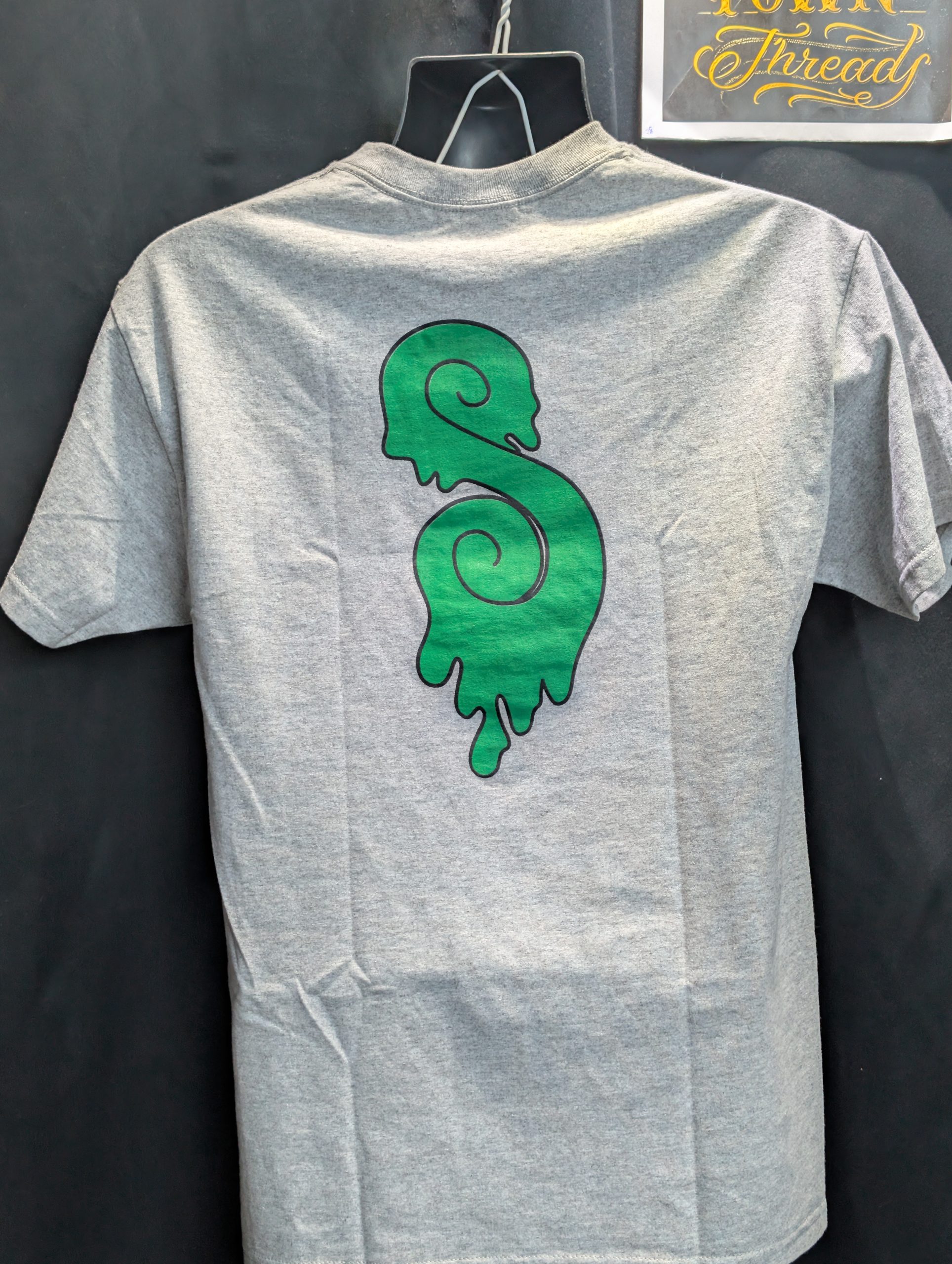 Grey shirt featuring green black Sticky Canna logo.