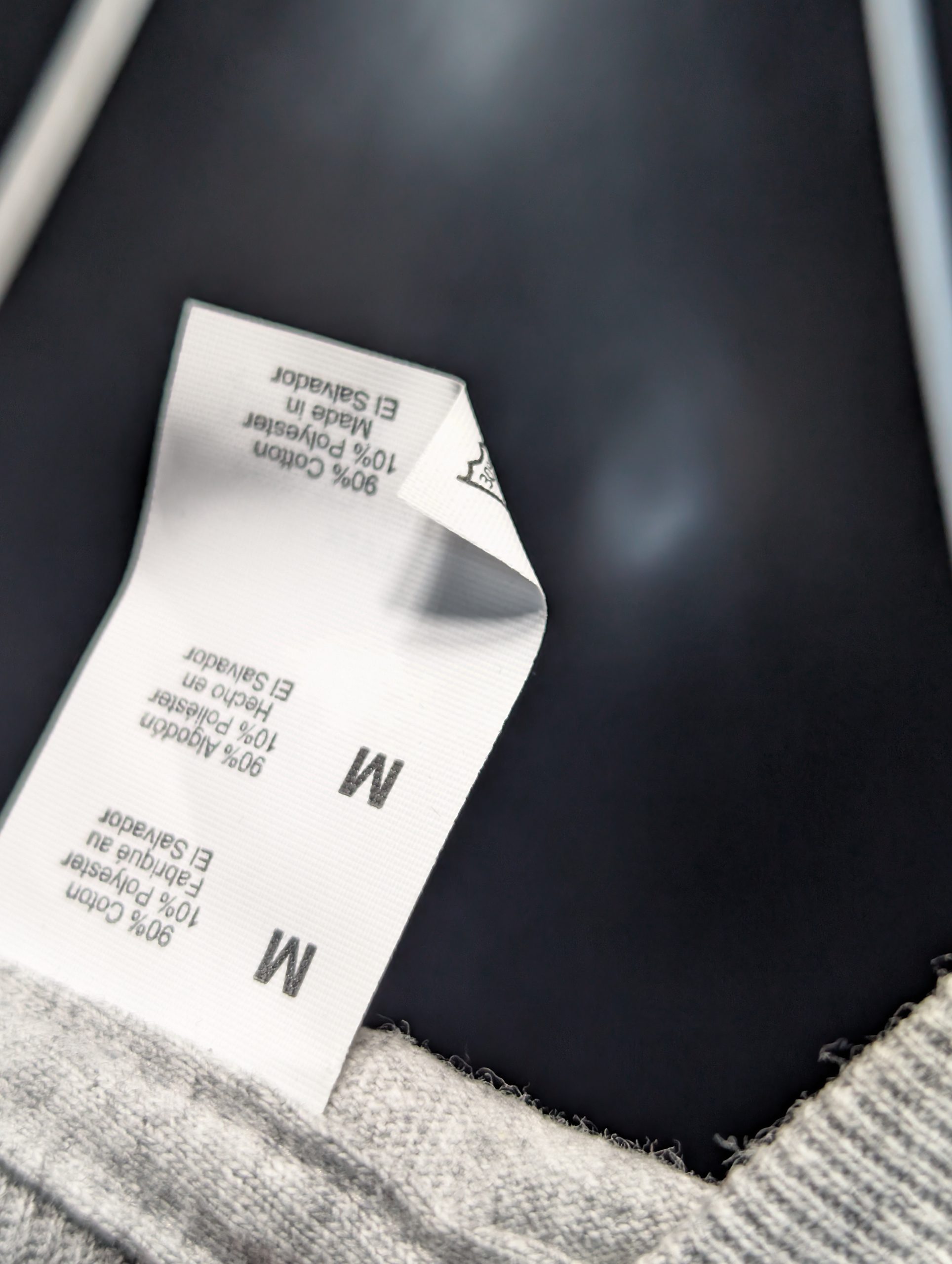 Grey shirt featuring green black Sticky Canna logo Tag.