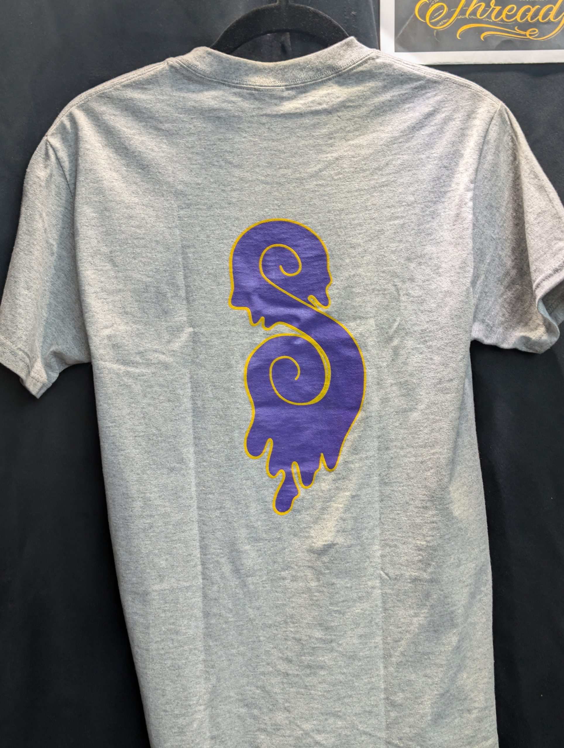 Grey shirt featuring purple yellow Sticky Canna logo back.