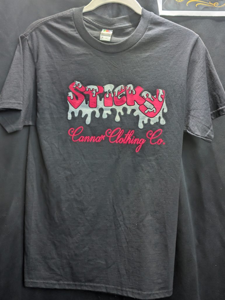 Black shirt featuring hot pink Sticky Canna logo.