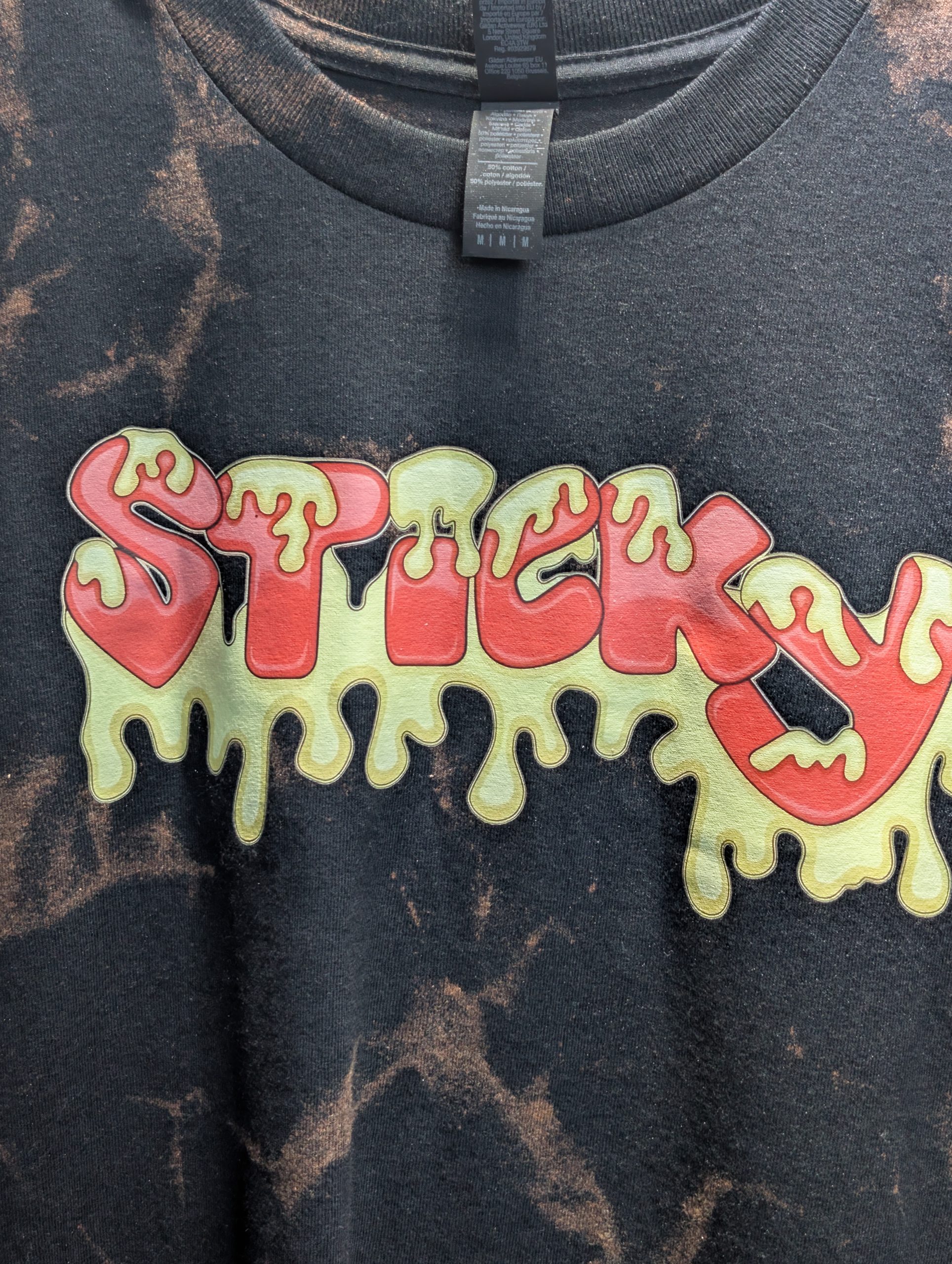 Black bleach washed shirt featuring red Sticky logo.