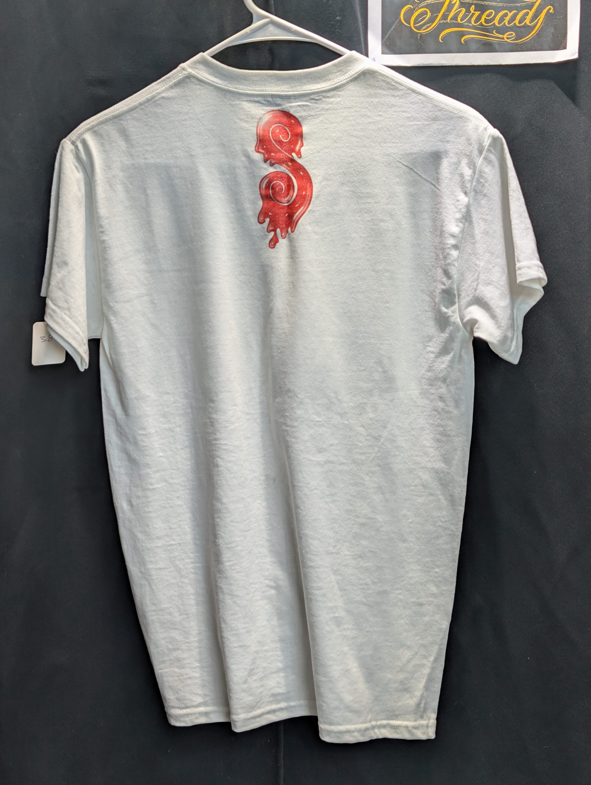 White shirt featuring red yellow Sticky Queens logo.