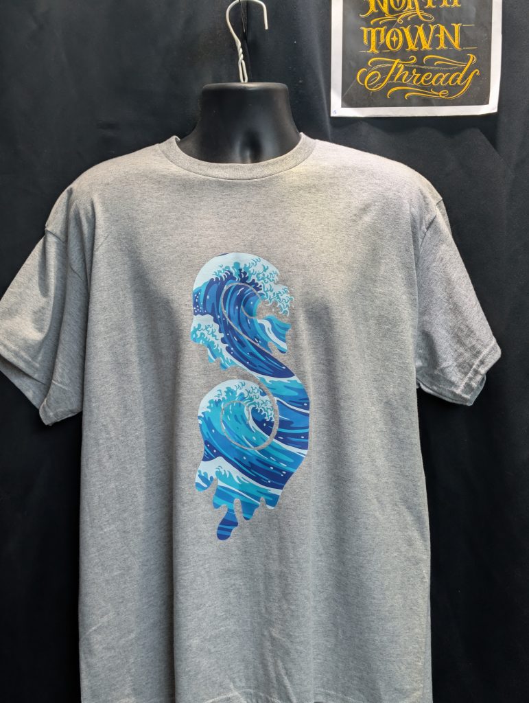 Grey shirt featuring blue wave Sticky Canna logo.