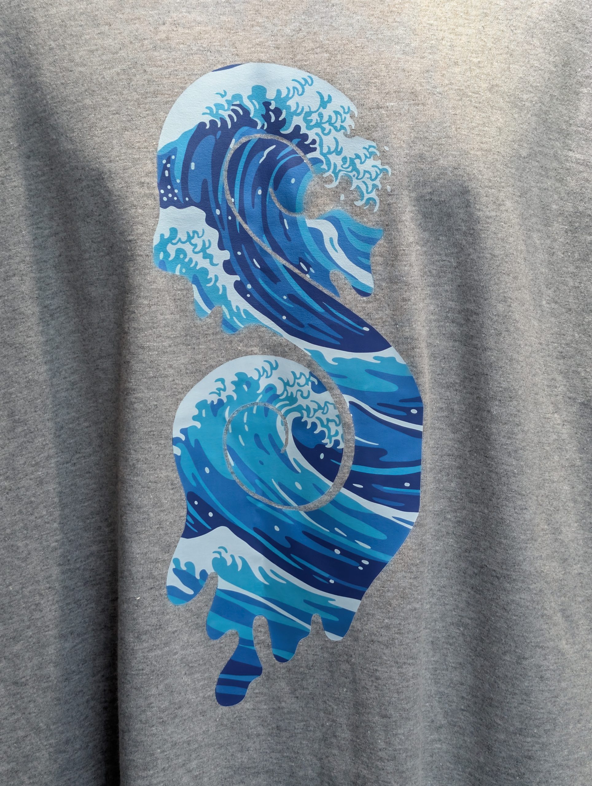 Grey shirt featuring blue wave Sticky Canna logo.
