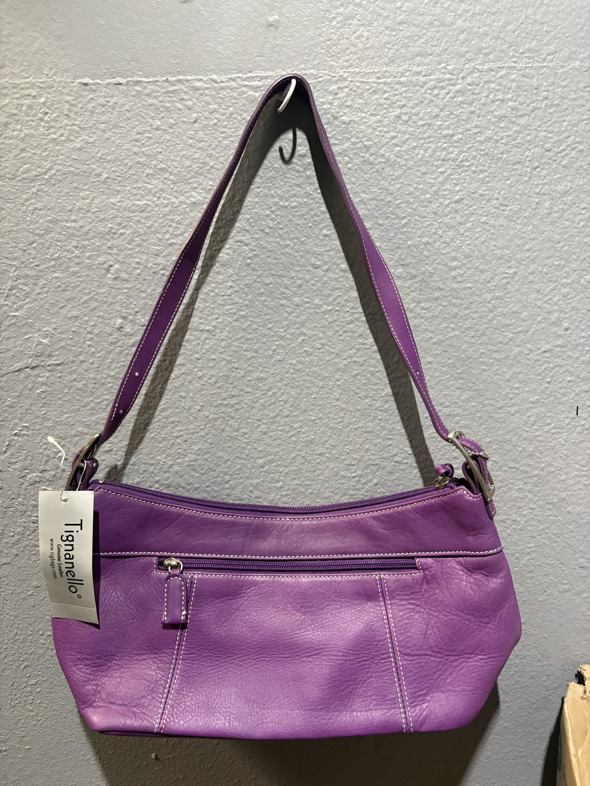 Tignanello purple genuine leather shoulder bag with white contrast stitching and exterior zip pocket.