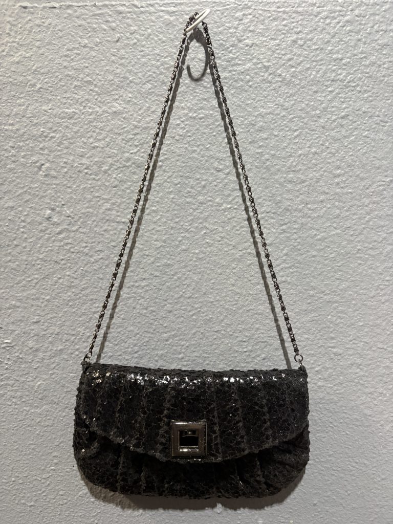 Jessica McClintock black sequin evening clutch with silver chain strap and square clasp.
