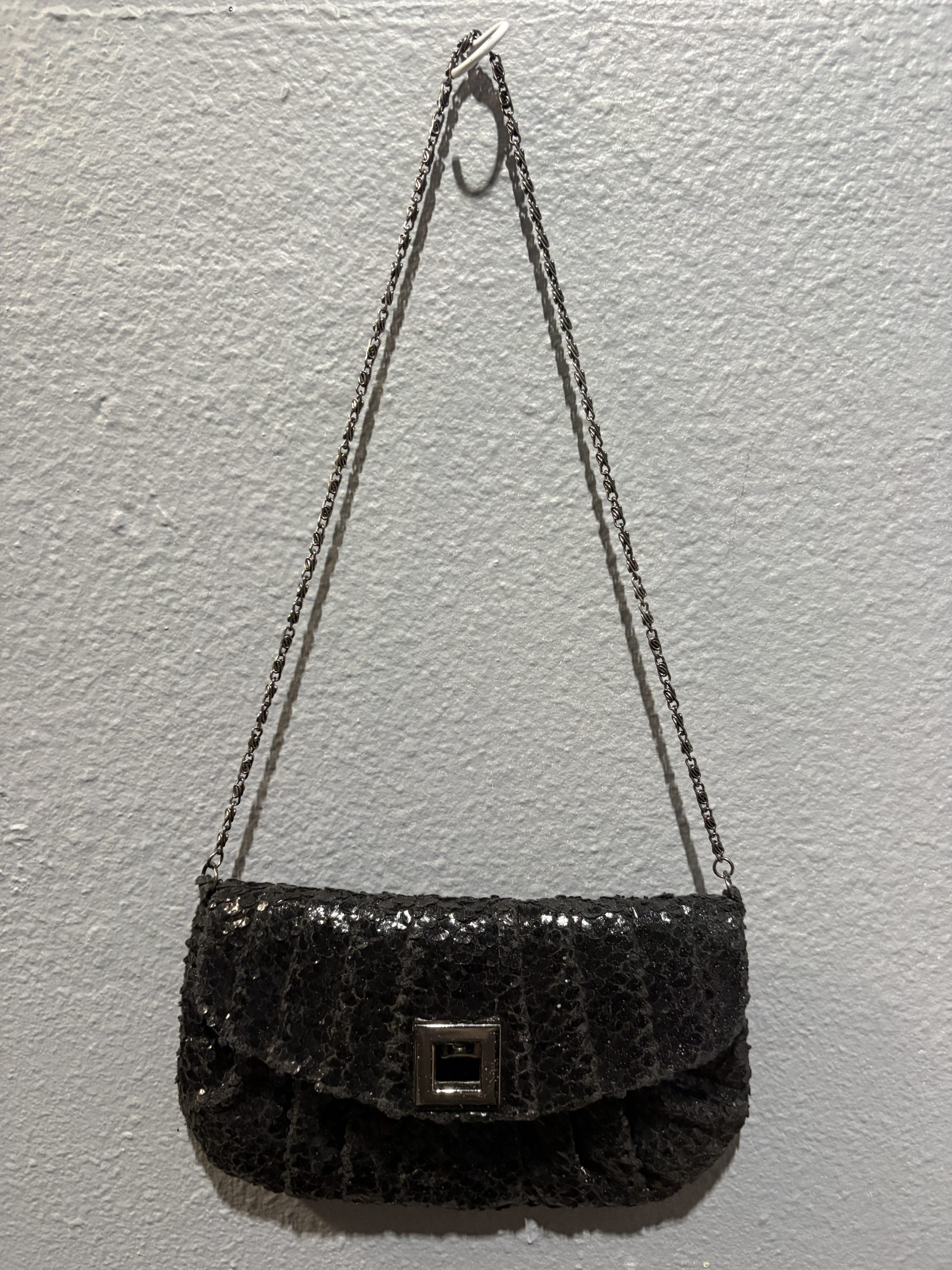 Jessica McClintock black sequin evening clutch with silver chain strap and square clasp.