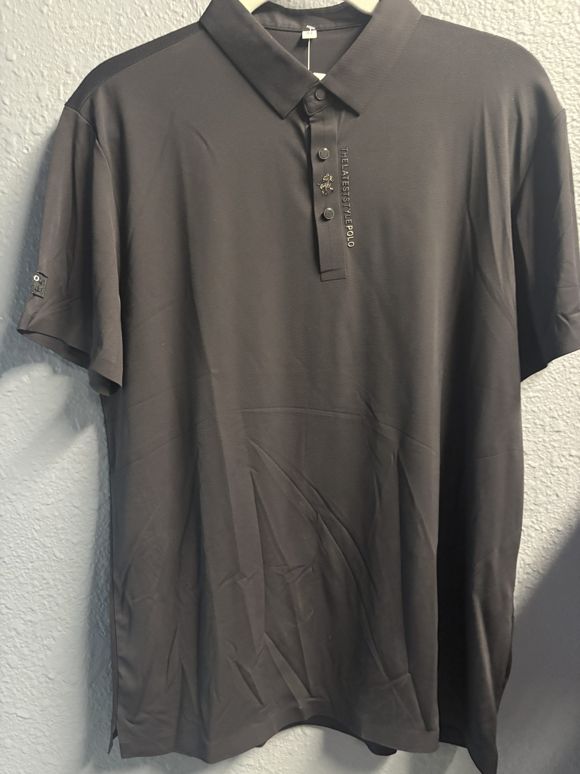 Premium dark grey polo shirt featuring embroidered equestrian logo and "THELATESTSTYLEPOLO" text on the placket.