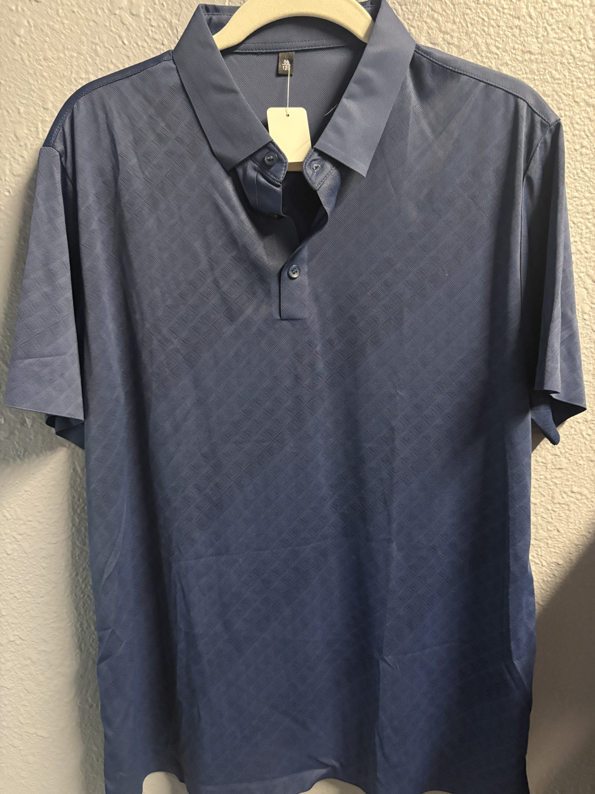 Deep blue performance polo shirt with a subtle geometric embossed texture and three-button collar.