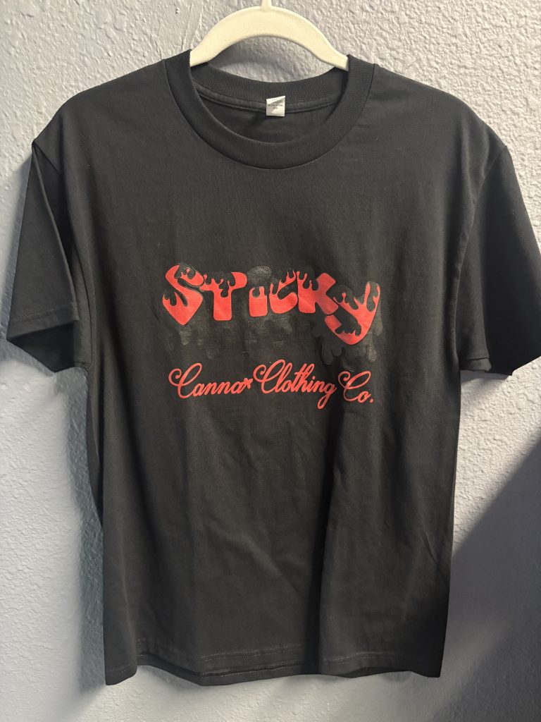 Black graphic t-shirt with red "Sticky" logo on front and red swirl art on back, size M.