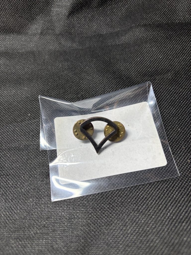 Vintage U.S. Army Private First Class (PFC) rank insignia pin in a protective sleeve.
