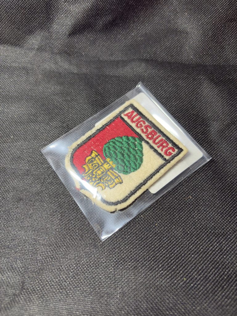 Vintage embroidered Augsburg city crest patch with pinecone heraldry design in a protective sleeve.