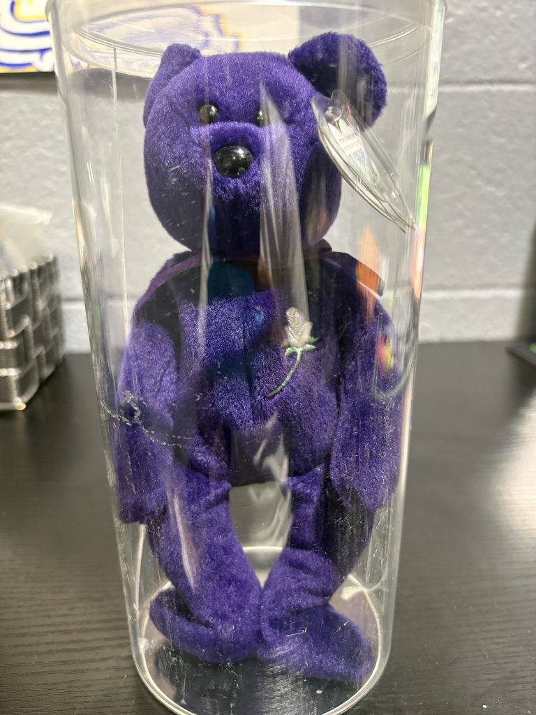 Beanie Baby Princess purple bear with white rose embroidery and heart tag in protective case.