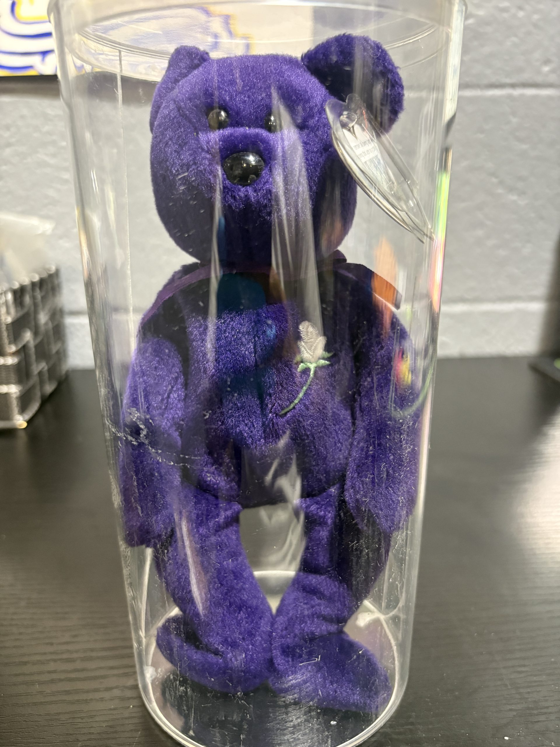 Beanie Baby Princess purple bear with white rose embroidery and heart tag in protective case.