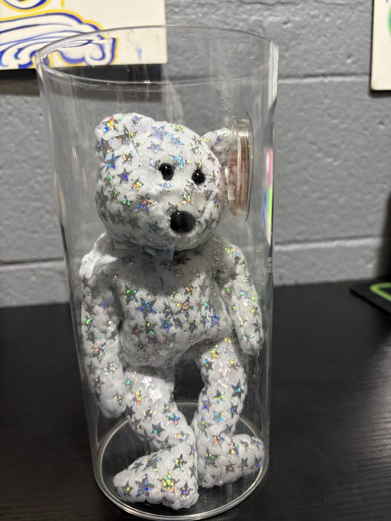 Ty Beanie Baby The Beginning bear covered in holographic stars with heart tag in protective case.